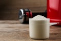 Measuring scoop of protein powder on wooden table. Space for text Royalty Free Stock Photo