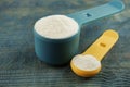 Measuring scoops of protein powder on wooden table, closeup