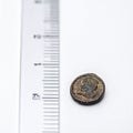 Measuring a Small Ancient Bronze Coin Royalty Free Stock Photo