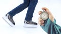 Measuring speed on skates with a stopwatch. hand with a stopwatch on the background of the legs of a man skating on an ice rink