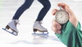 Measuring speed on skates with a stopwatch. hand with a stopwatch on the background of the legs of a man skating on an ice rink