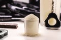 Measuring spoon with creatine, whey or casein, whey supplements, exercise protein bar, gym background, muscle mass gain