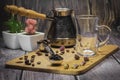 Measuring spoon for tea and coffee with coffee beans and dry tea leaves on a wooden plate