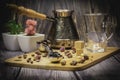 Measuring spoon for tea and coffee with coffee beans and dry tea leaves on a wooden plate