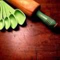 Measuring spoons and antique wood rolling pin with painted green handle Royalty Free Stock Photo