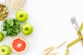 Measuring tape, apples, oat meal and grapefruit for loosing weight on white background top view mockup Royalty Free Stock Photo