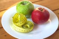 Measuring tape and green apples on plate Royalty Free Stock Photo