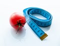 Measuring tape and juicy tomato, the concept of healthy nutrition and weight loss Royalty Free Stock Photo