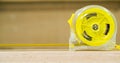 Measuring tape placed on the wooden table in a domestic joinery with a neutral background and copy space Royalty Free Stock Photo