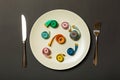 Measuring tape in a plate with fork and knife on both sides on black background. Top view of weight loss concept