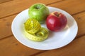 Measuring tape and ripe apples on plate Royalty Free Stock Photo