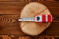 Measuring tape on stump, wooden background