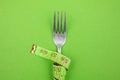 The measuring tape is wrapped around the fork. Proper nutrition. Medical fasting. Diet for weight loss concept Royalty Free Stock Photo