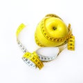 Measuring tape wrapped around fresh tasty yellow apple isolated on white background. Diet, weight loss, fitness, sport Royalty Free Stock Photo