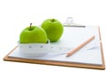 Measuring tape wrapped around a green apple and clipboard Royalty Free Stock Photo