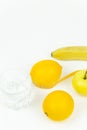 A measuring tape wrapped around a green apple and two lemons and a banana as a symbol of diet. Royalty Free Stock Photo