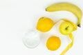 A measuring tape wrapped around a green apple and two lemons and a banana as a symbol of diet Royalty Free Stock Photo