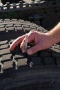 Measuring tread depth tractor-trailer truck tire Royalty Free Stock Photo