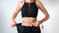 Measuring the waist with a measuring tape - a woman has lost weight, clothes have become larger