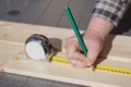 Measuring a wooden board with ruler and pencil. Royalty Free Stock Photo