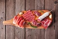 Meat appetizer platter with sausage, prosciutto, ham and salami, top view on a serving board against wood Royalty Free Stock Photo