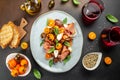 meat appetizer salad for wine prosciutto ham, cherry tomatoes and cream cheese with basil leaves, antipasto. place for Royalty Free Stock Photo