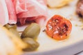 Meat appetizer selection. Salami, prosciutto, bread sticks, baguette, olives and sun-dried tomatoes, selective focus.