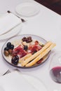 Meat appetizer selection. Salami, prosciutto, bread sticks, baguette, olives and sun-dried tomatoes, selective focus.