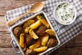 Meat balls with potato wedges in a baking dish and sour cream cl Royalty Free Stock Photo