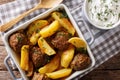 Meat balls with potatoes in a baking dish and sour cream close-up on a table. horizontal top view Royalty Free Stock Photo