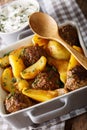 Meat balls with potatoes in a baking dish and sour cream close-up on a table. Vertical Royalty Free Stock Photo