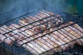 Meat barbecue. Sausages with cheese spun in bacon on a metal grill close-up Royalty Free Stock Photo