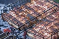 Meat barbecue. Sausages with cheese spun in bacon on a metal grill close-up Royalty Free Stock Photo