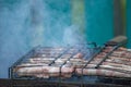 Meat barbecue. Sausages with cheese spun in bacon on a metal grill close-up Royalty Free Stock Photo