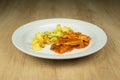 Meat with boiled potatoes on plate on wooden table Royalty Free Stock Photo