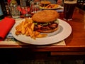 Meat burger with chips served on plate at the coveted table