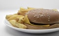 Meat burger with French fries on a white plate. Delicious fast food breakfast. Hamburger Royalty Free Stock Photo