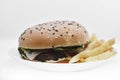 Meat burger with French fries on a white plate. Delicious fast food breakfast. Hamburger Royalty Free Stock Photo