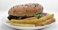 Meat burger with French fries on a white plate. Delicious fast food breakfast. Hamburger Royalty Free Stock Photo