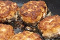 Meat burgers or cutlet-shaped patty being shallow fried in oil on a frying pan, close up. Russian kotlety Royalty Free Stock Photo
