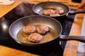 Meat burgers or cutlet-shaped patty being shallow fried in oil on a frying pan Royalty Free Stock Photo