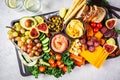 Meat and cheese appetizer platter. Sausage, cheese, hummus, vegetables, fruits and bread on black tray Royalty Free Stock Photo