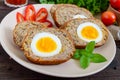 Meat cutlet with boiled egg, pieces on a ceramic plate on a dark wooden background. Mini meat rolls.