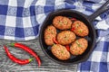 Meat cutlets in iron frying pan sprinkled with chili pieces Royalty Free Stock Photo