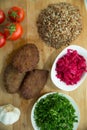 Meat cutlets, baked buckwheat on a wooden board . Red cabbage sauerkraut . Garlic, Onion, Tomatoes. Chopped coriander. Homemade