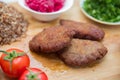 Meat cutlets, baked buckwheat on a wooden board . Red cabbage sauerkraut . Garlic, Onion, Tomatoes. Chopped coriander. Homemade