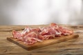 meat delicacy in slicing on a wooden surface. dry-cured pork on a tray. traditional snack in rustic style.