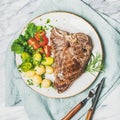 Meat dinner plate with cooked beef tbone steak, square crop