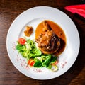 Meat dish. Appetizing beef cheeks in sauce with tomatoes and bas Royalty Free Stock Photo