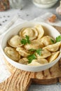 Meat dumplings - russian pelmeni, ravioli with meat on a white plate on a wooden board Royalty Free Stock Photo